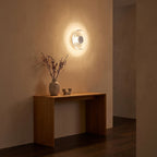 Slim Crystal Disc LED Wall Light in a hallway above a timber console
