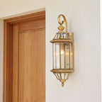 Slim Cylinder Brass Glass Outdoor Wall Light beside a timber front door