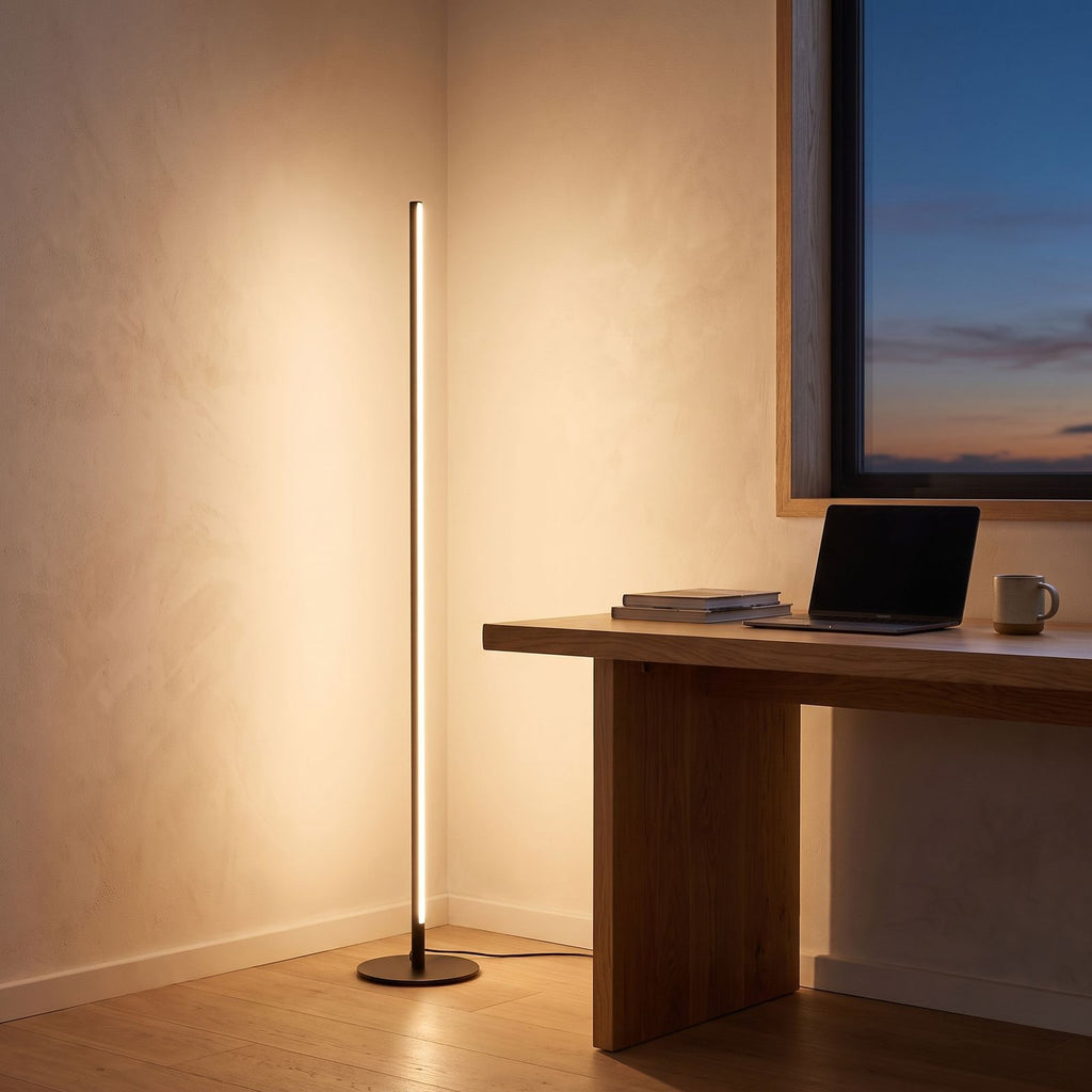 Slim linear LED floor lamp in a home office corner beside a desk
