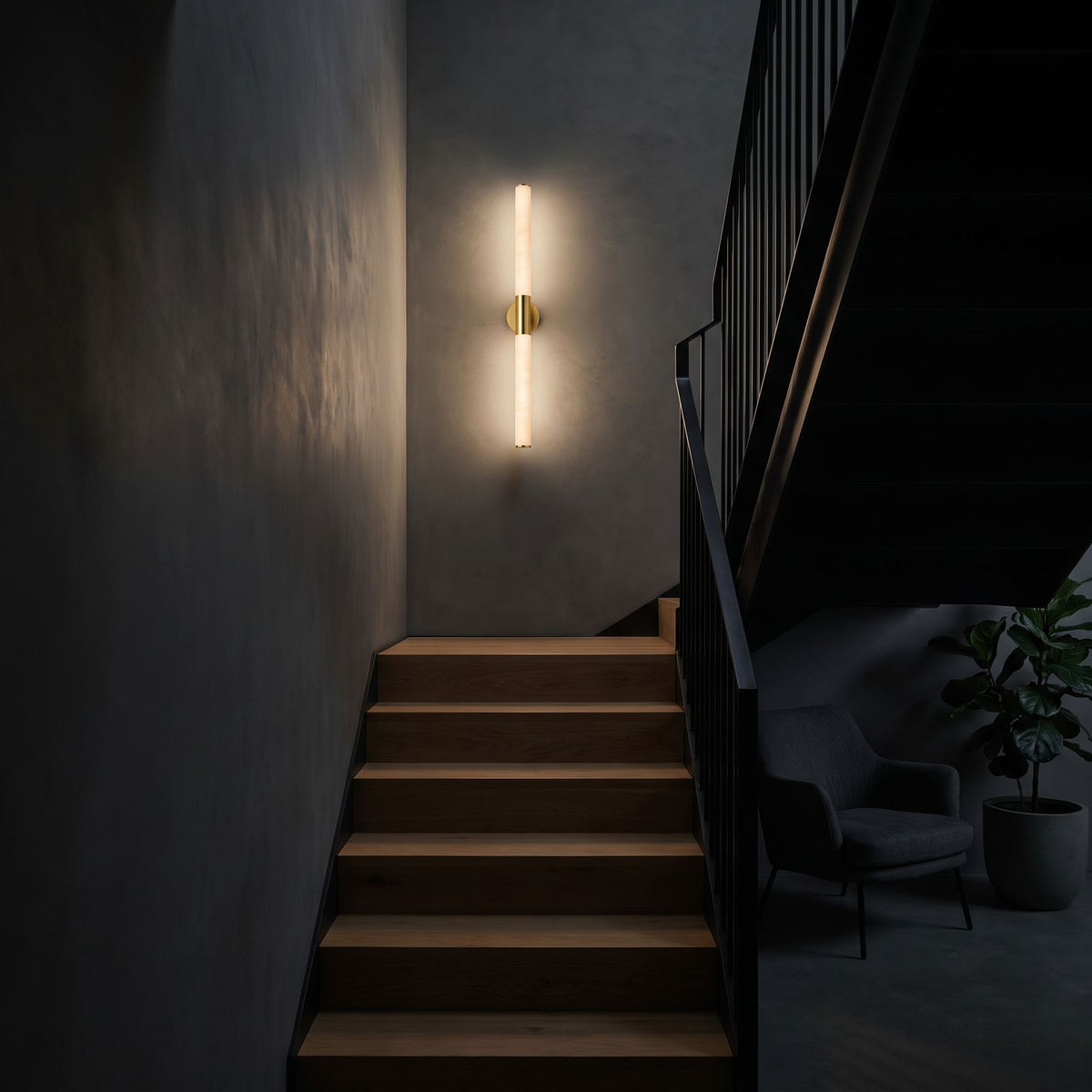 The marble tube wall light lit at night on a staircase wall, the only light in the stairwell