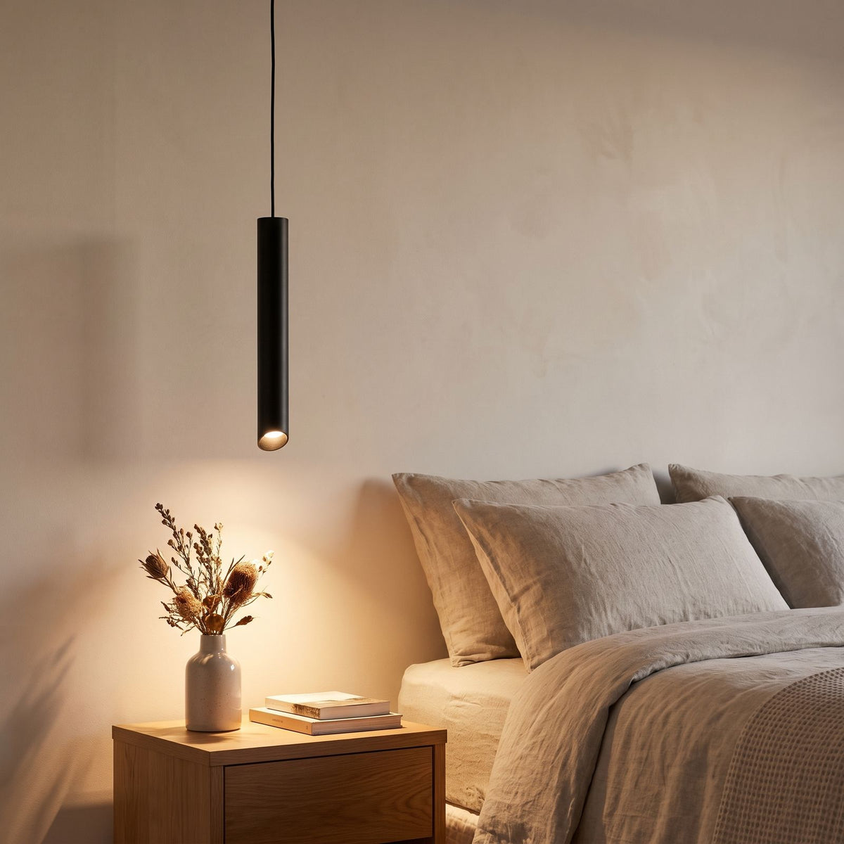 Slim Metal Cylinder Pendant Light beside a bed