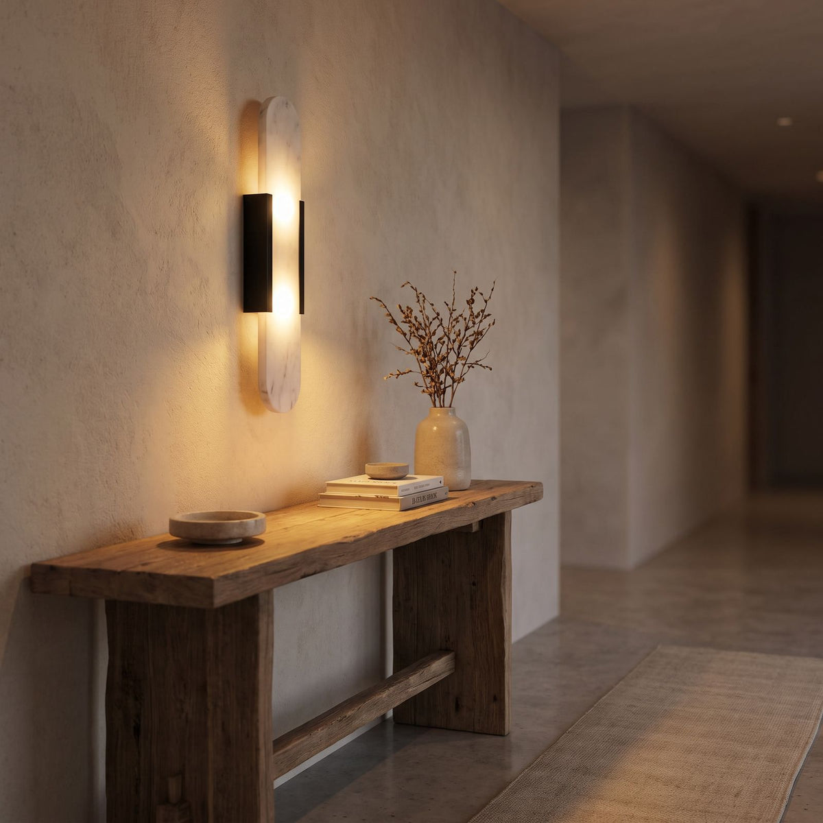 Slim Natural Marble Column Up Down Wall Light in a hallway above a timber console