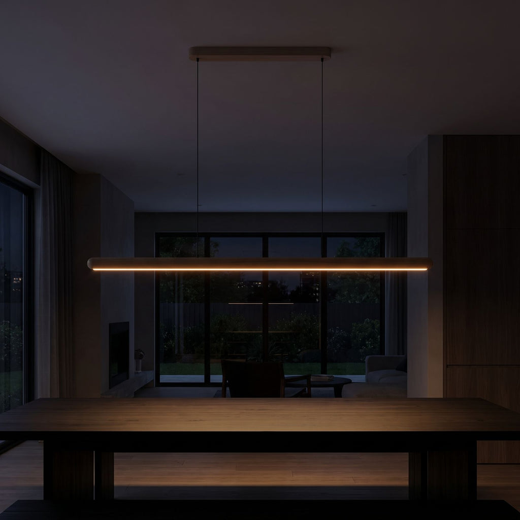 Slim wood bar linear LED pendant light over a dining table at night