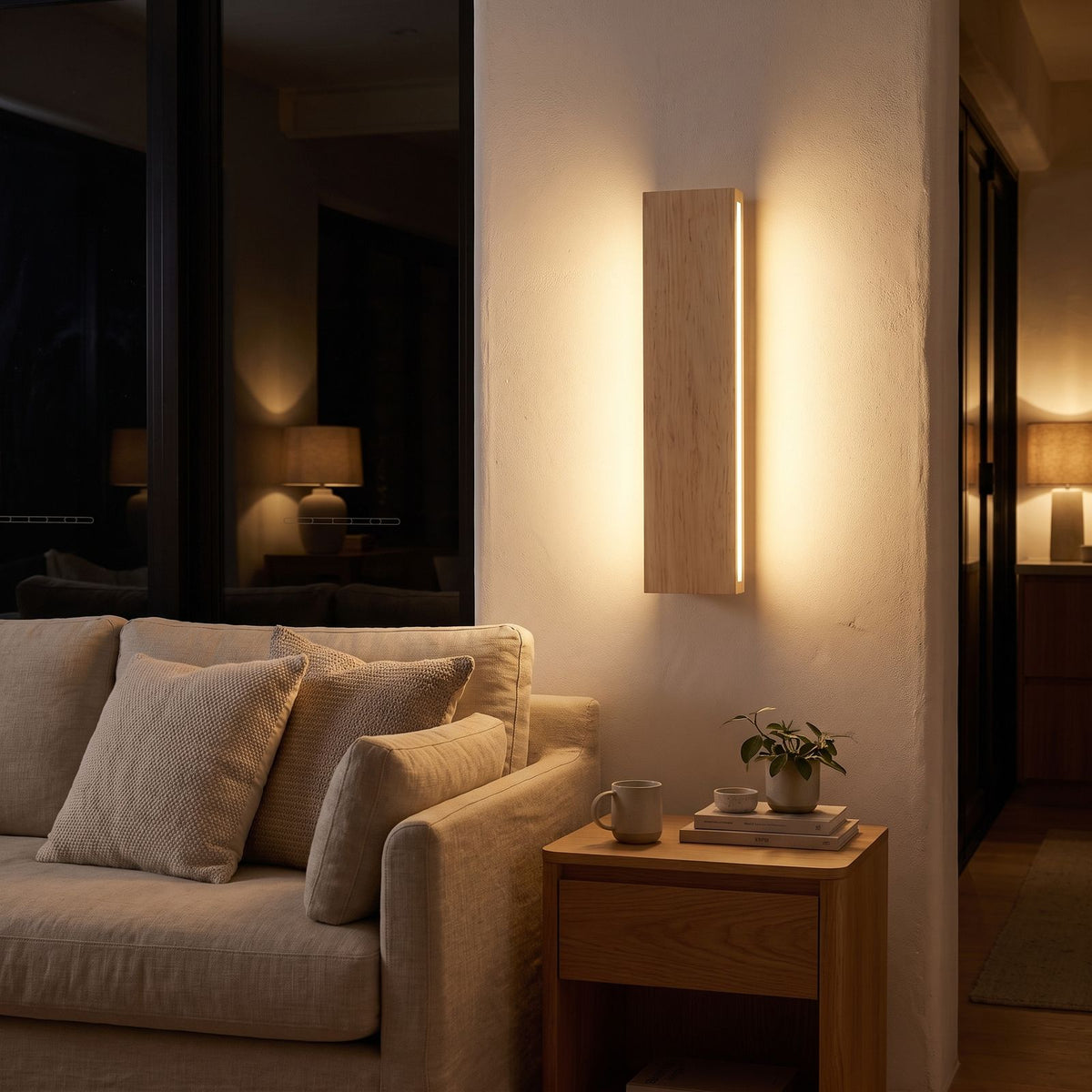 Slim wood plank wall sconce beside a living room sofa at night