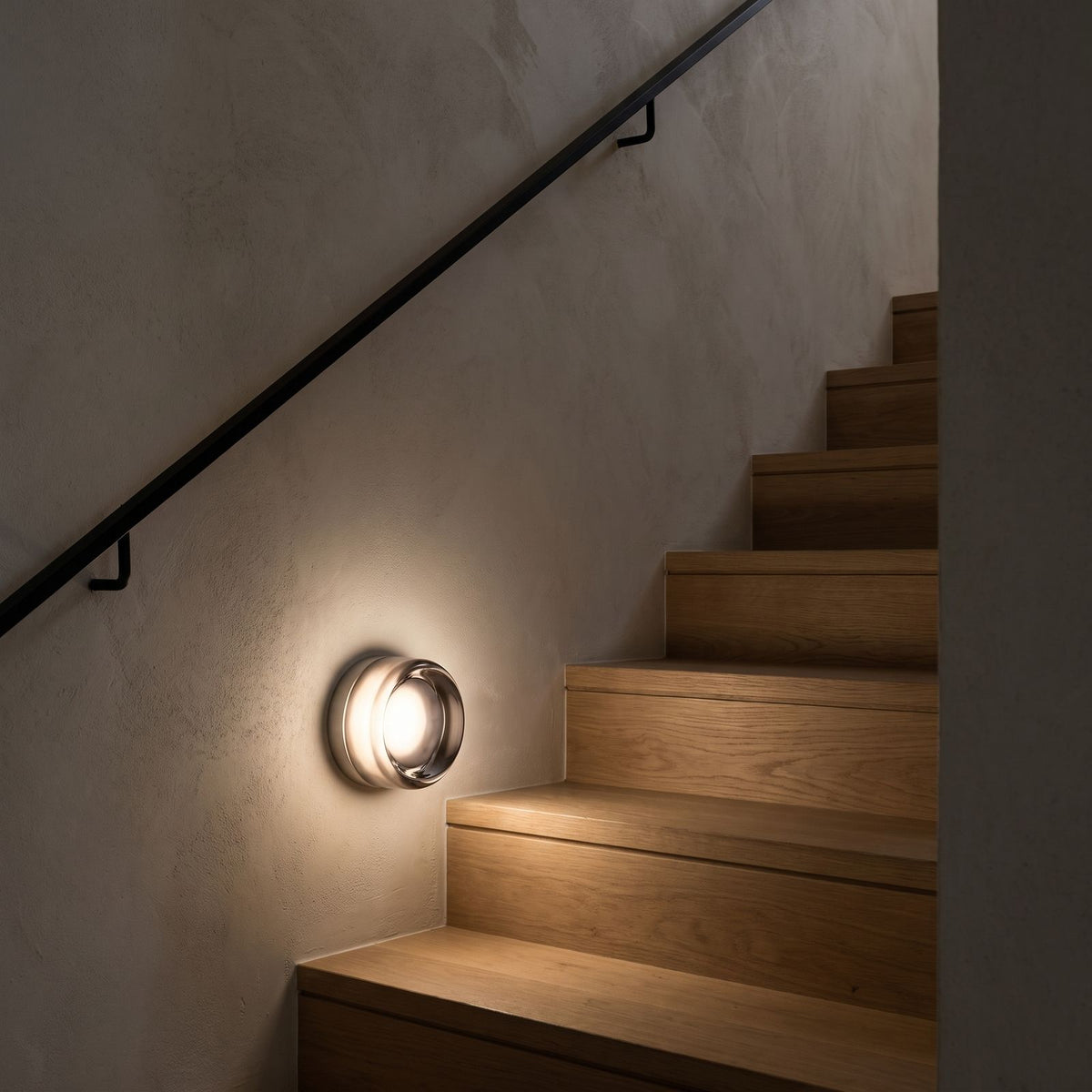 Smoked Dimple Glass LED Wall Light beside a staircase at night