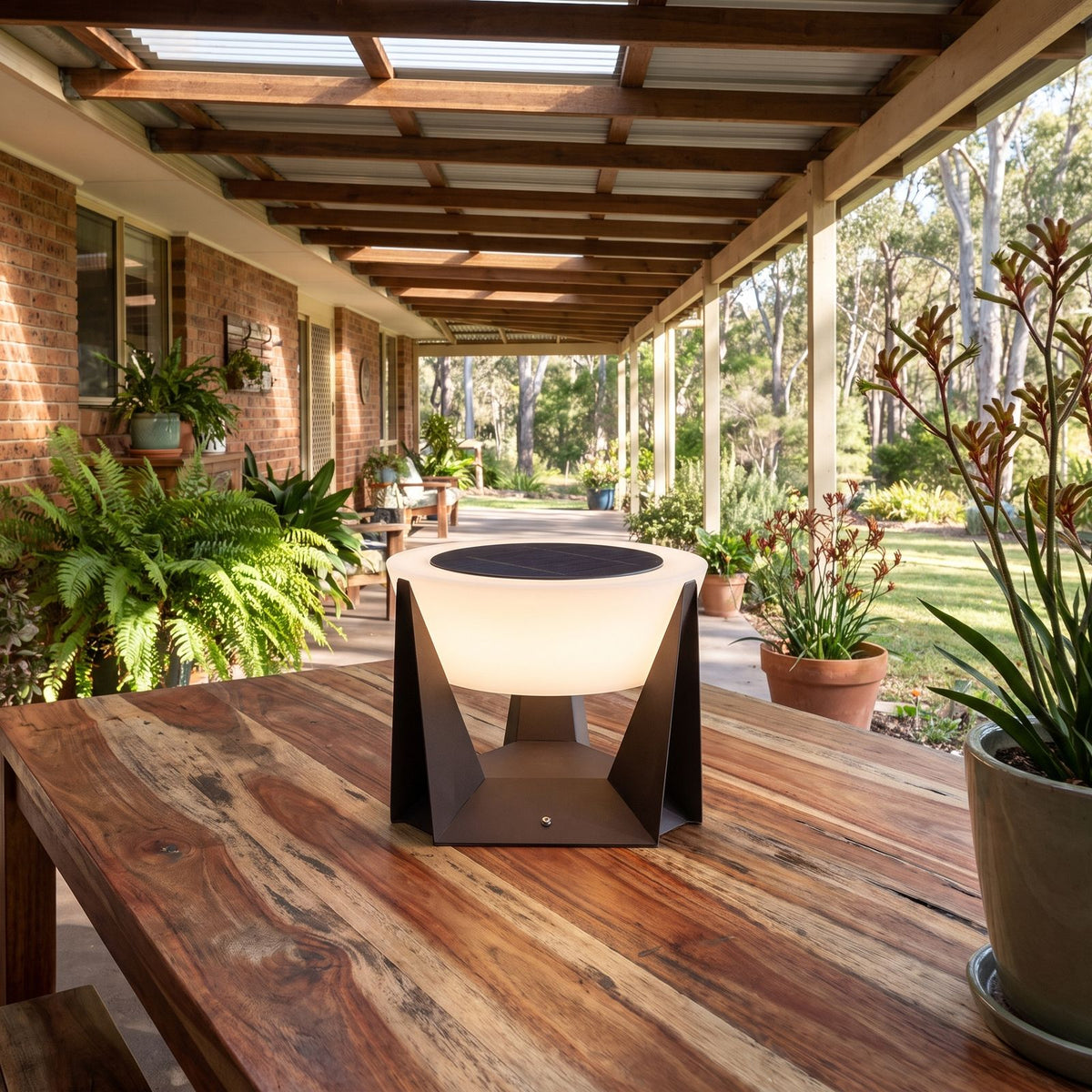 Solar Iron and Acrylic Outdoor Table Lamp on an outdoor table on a covered patio