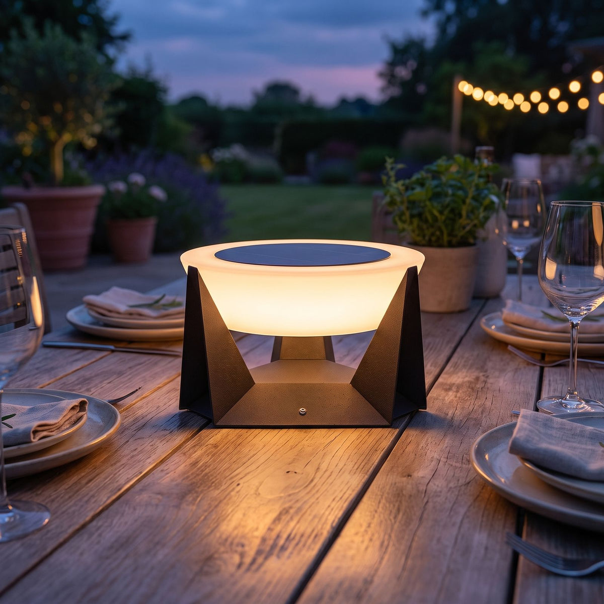 Solar Iron and Acrylic Outdoor Table Lamp on an alfresco dining table at dusk