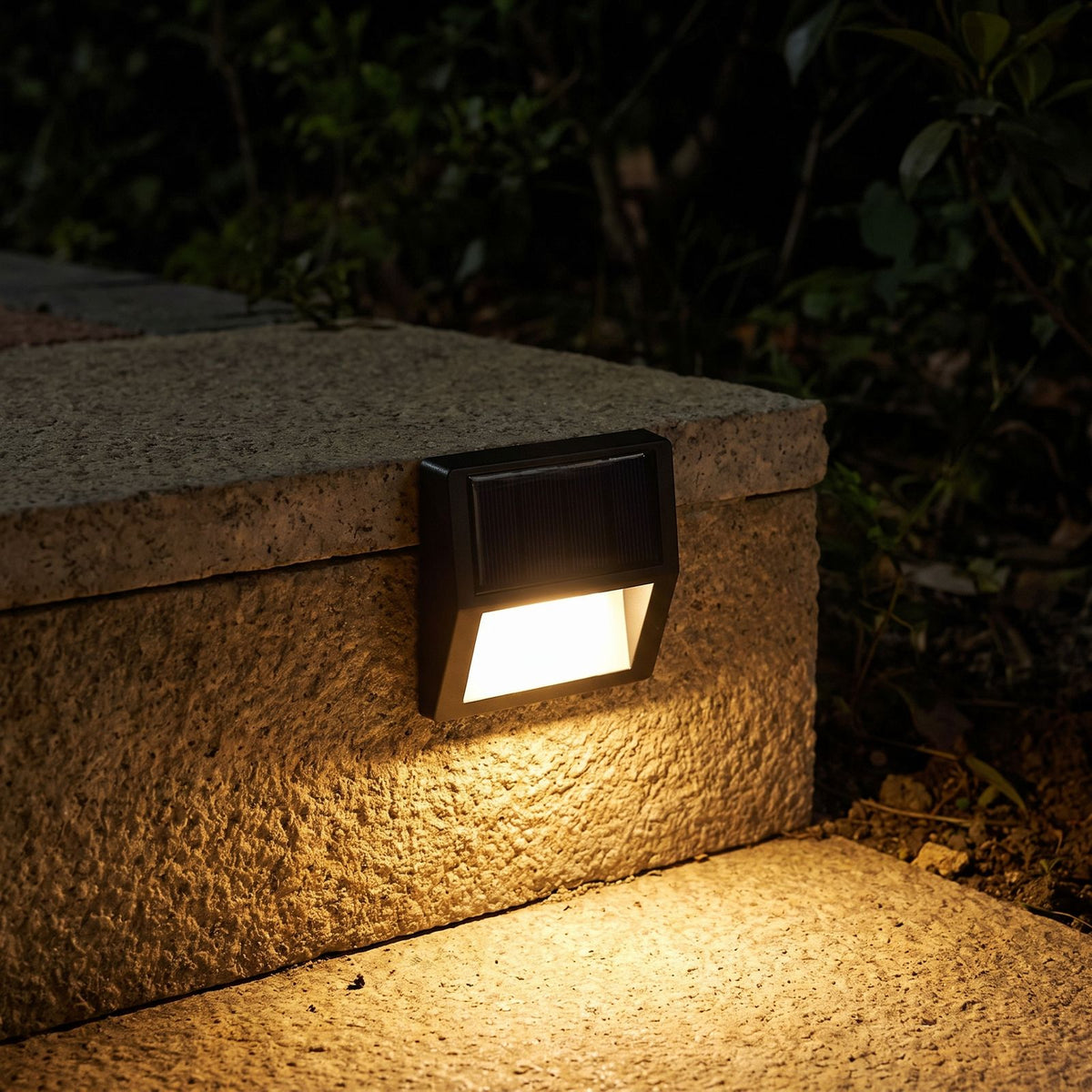 Solar LED Step and Deck Light glowing on a garden wall at night