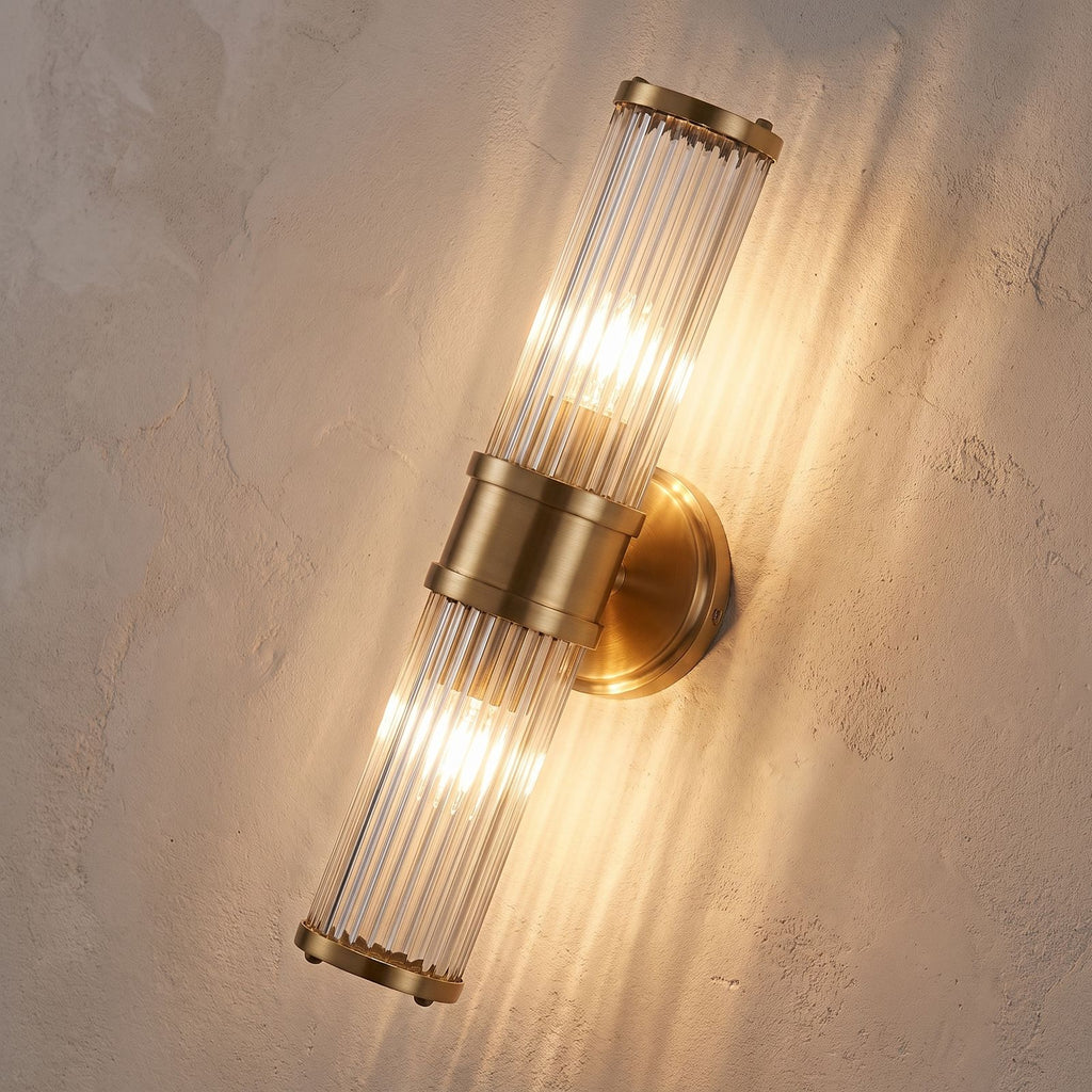 Ribbed Crystal Glass Tube Gold Wall Light with two tubes, close view at 45 degrees on a plaster wall