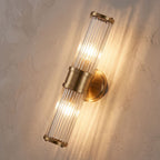 Ribbed Crystal Glass Tube Gold Wall Light with two tubes, close view at 45 degrees on a plaster wall
