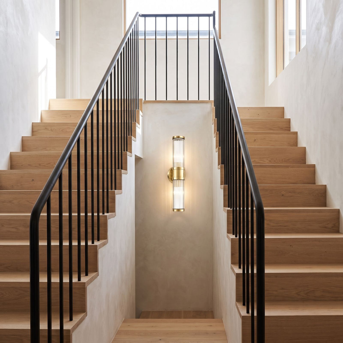 Ribbed Crystal Glass Tube Gold Wall Light with two tubes on a staircase wall in a hallway landing