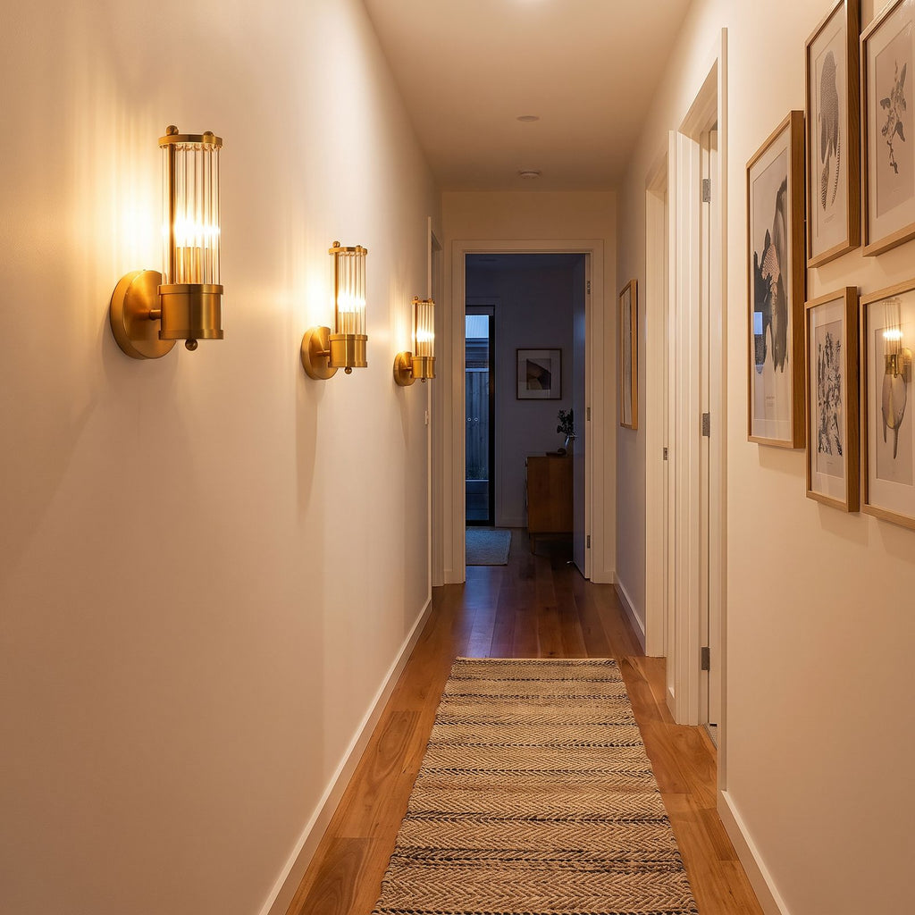 Row of three Ribbed Crystal Glass Tube Gold Wall Lights with one tube along a hallway wall