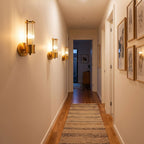 Row of three Ribbed Crystal Glass Tube Gold Wall Lights with one tube along a hallway wall
