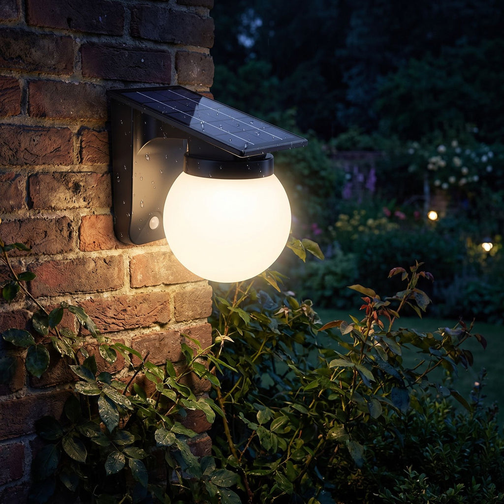 Spherical Solar Outdoor Wall Light glowing on a garden wall at night