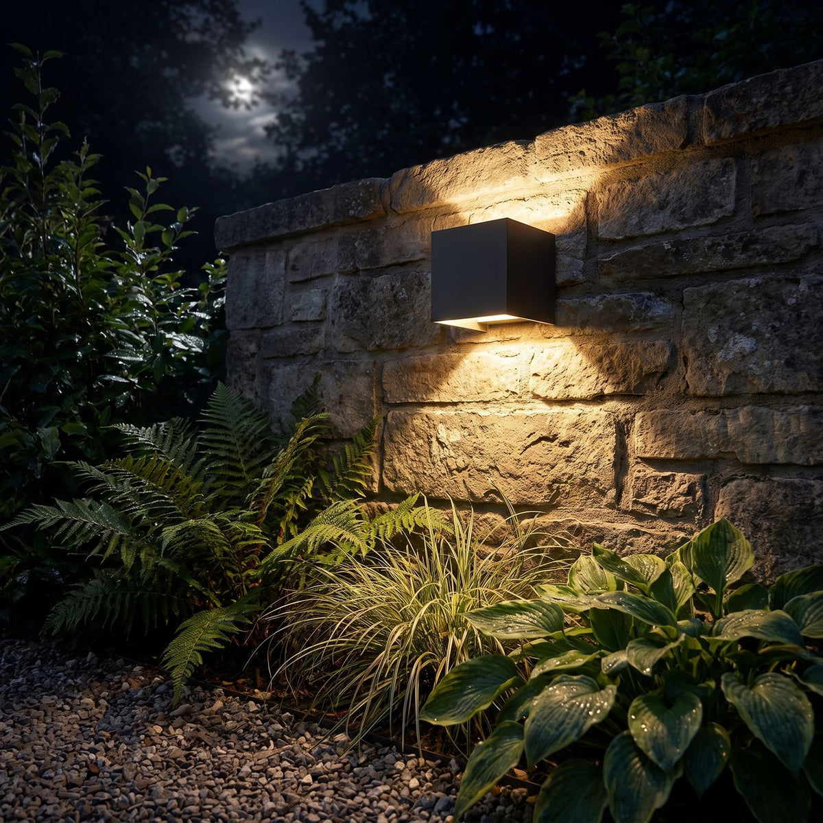 Square Adjustable Beam LED Outdoor Wall Light glowing on a garden wall at night