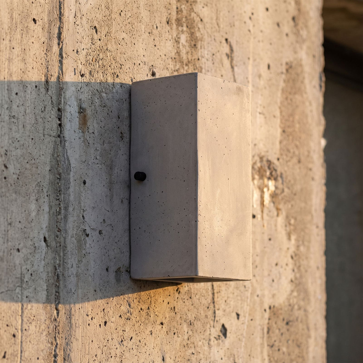 Square Cement Box Outdoor Wall Light, close view at 45 degrees on a stone wall