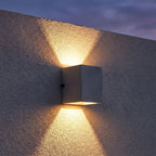 Square Cement Box Outdoor Wall Light on a porch wall at dusk