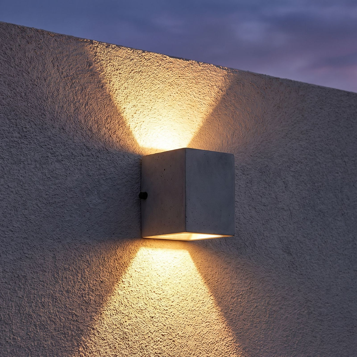 Square Cement Box Outdoor Wall Light on a porch wall at dusk