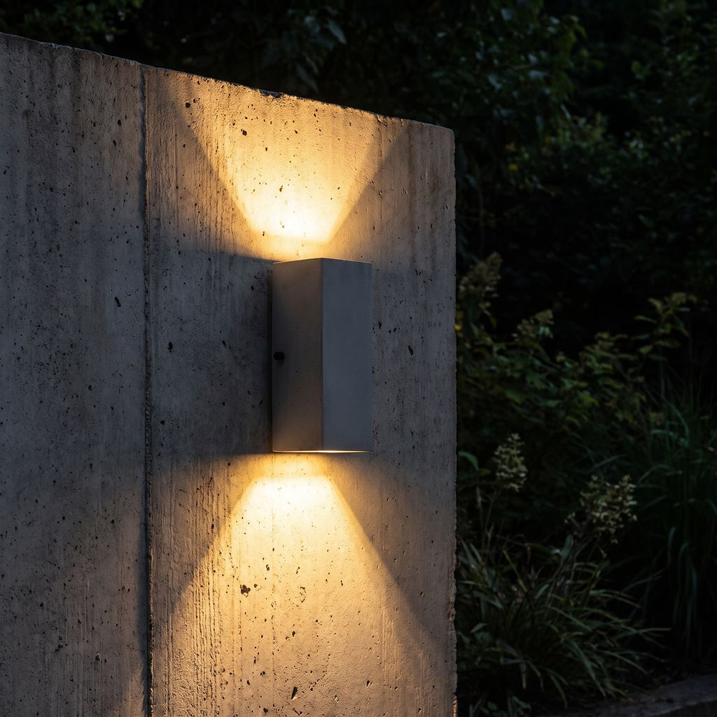Square Cement Box Outdoor Wall Light glowing on a garden wall at night