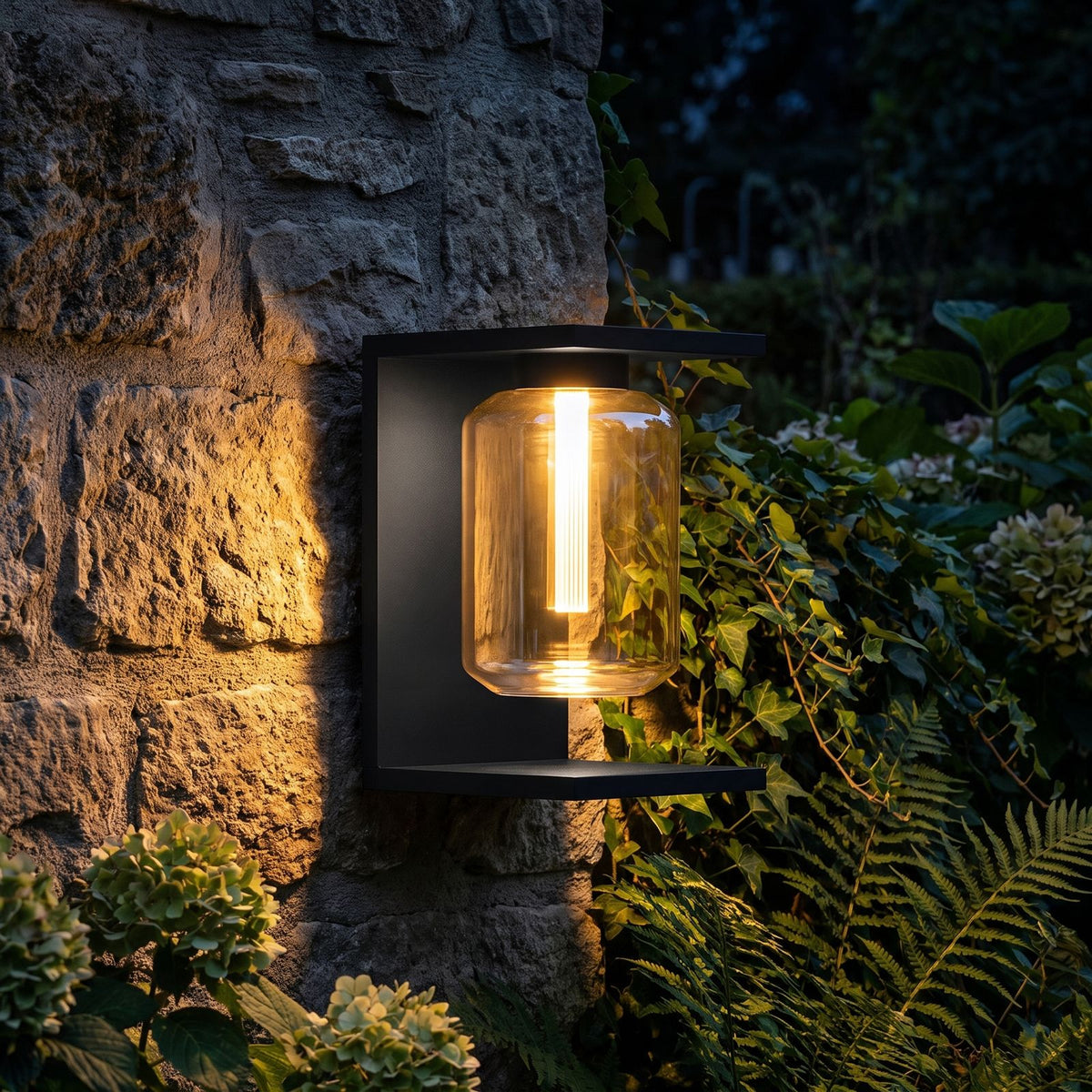 Square Frame Glass Outdoor Wall Lantern glowing on a garden wall at night