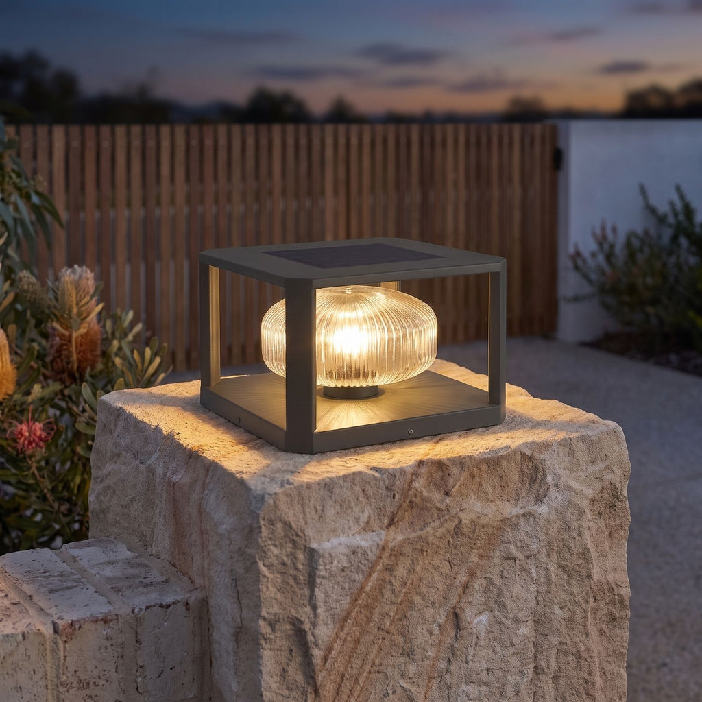 Square frame solar pillar light on a brick gate pier beside a driveway