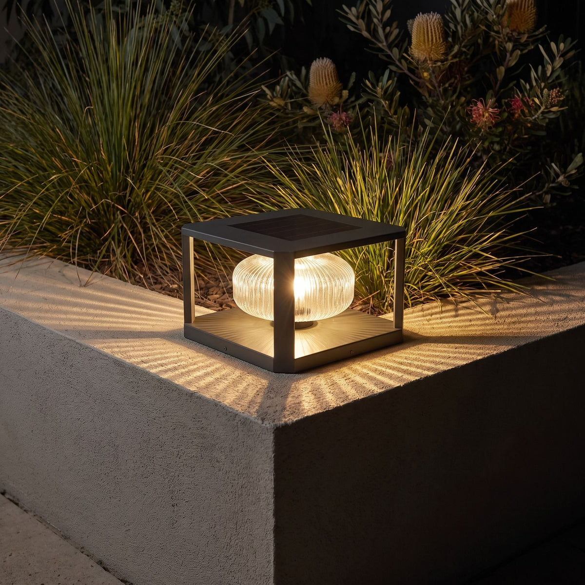 Square frame solar pillar light on a garden wall corner at night