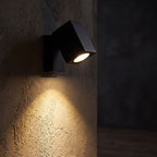 Square Head Rotatable Metal Spotlight Wall Light glowing on a plaster wall at night