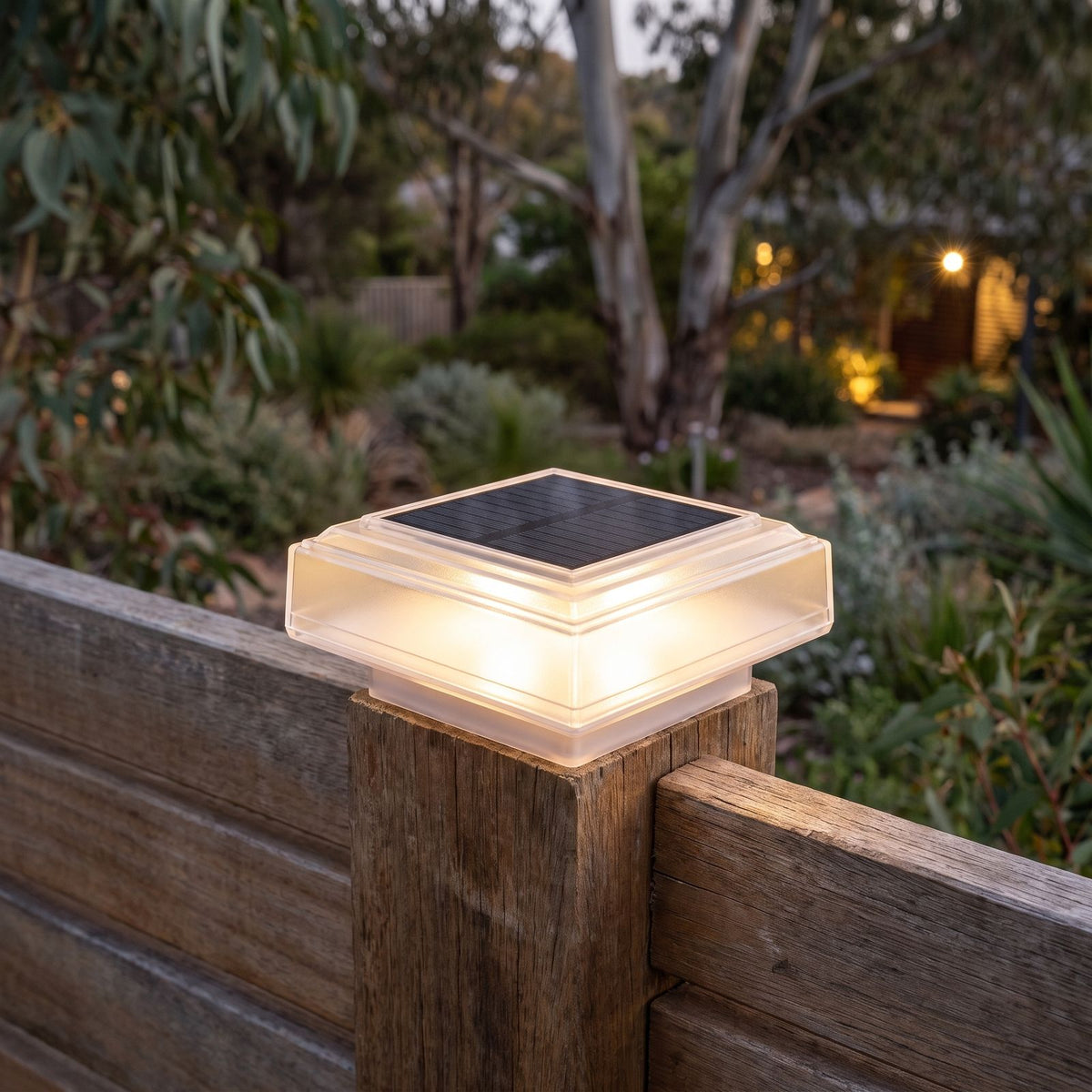 Square Post Cap Solar Fence Light on a timber fence post at dusk