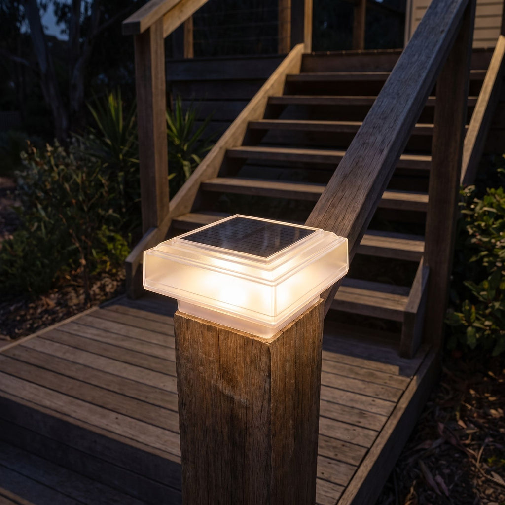 Square solar post cap light on a deck stair post at night