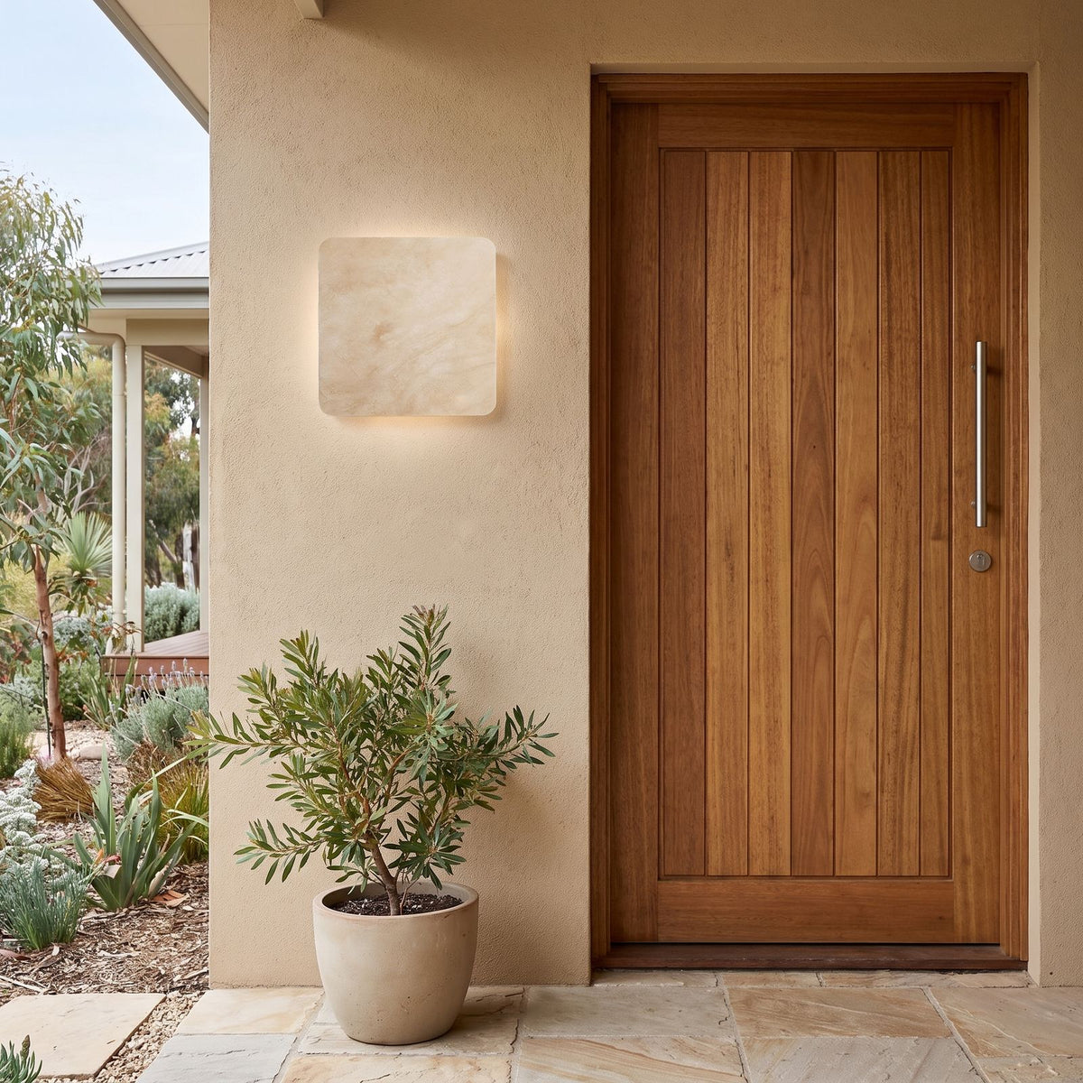 Square Travertine Stone LED Outdoor Wall Light beside a timber front door