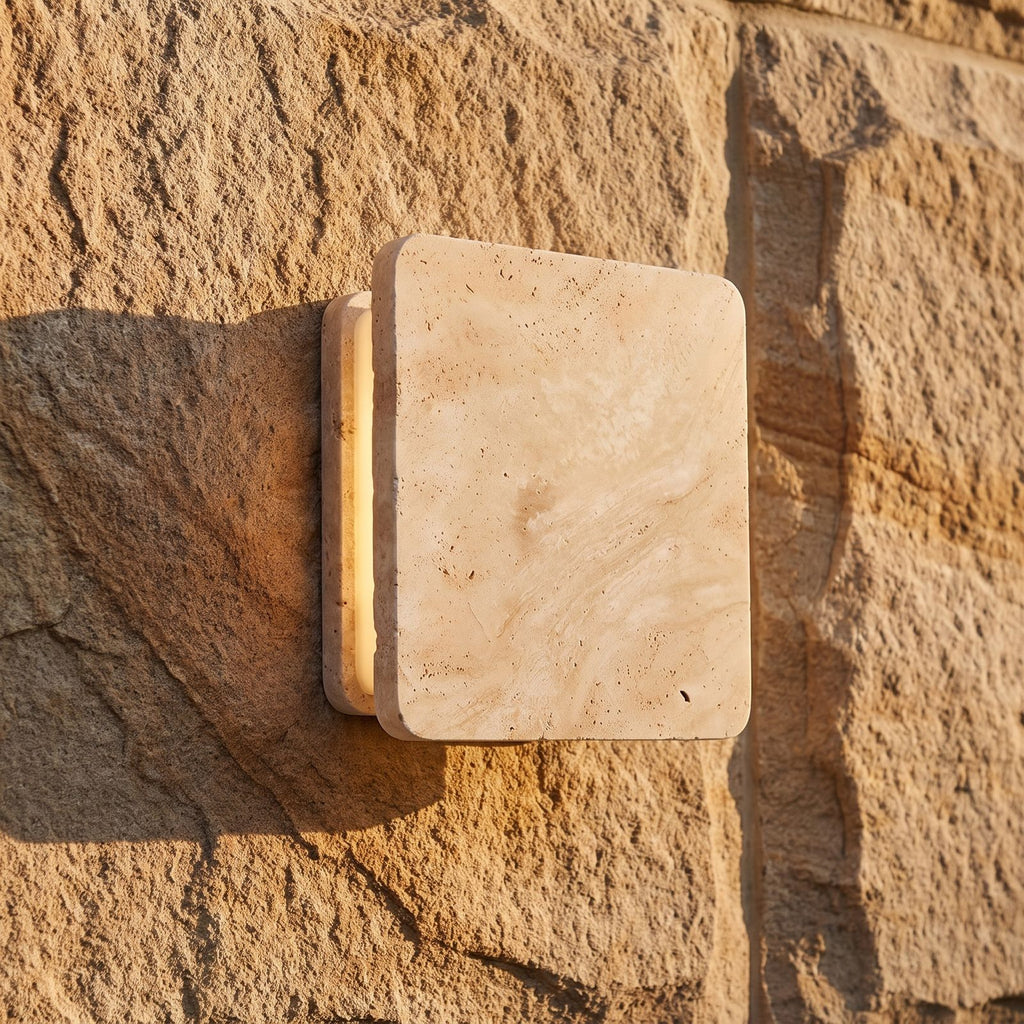 Square Travertine Stone LED Outdoor Wall Light, close view at 45 degrees on a stone wall