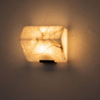 Stacked Alabaster Block Stair Wall Light glowing on a plaster wall at night