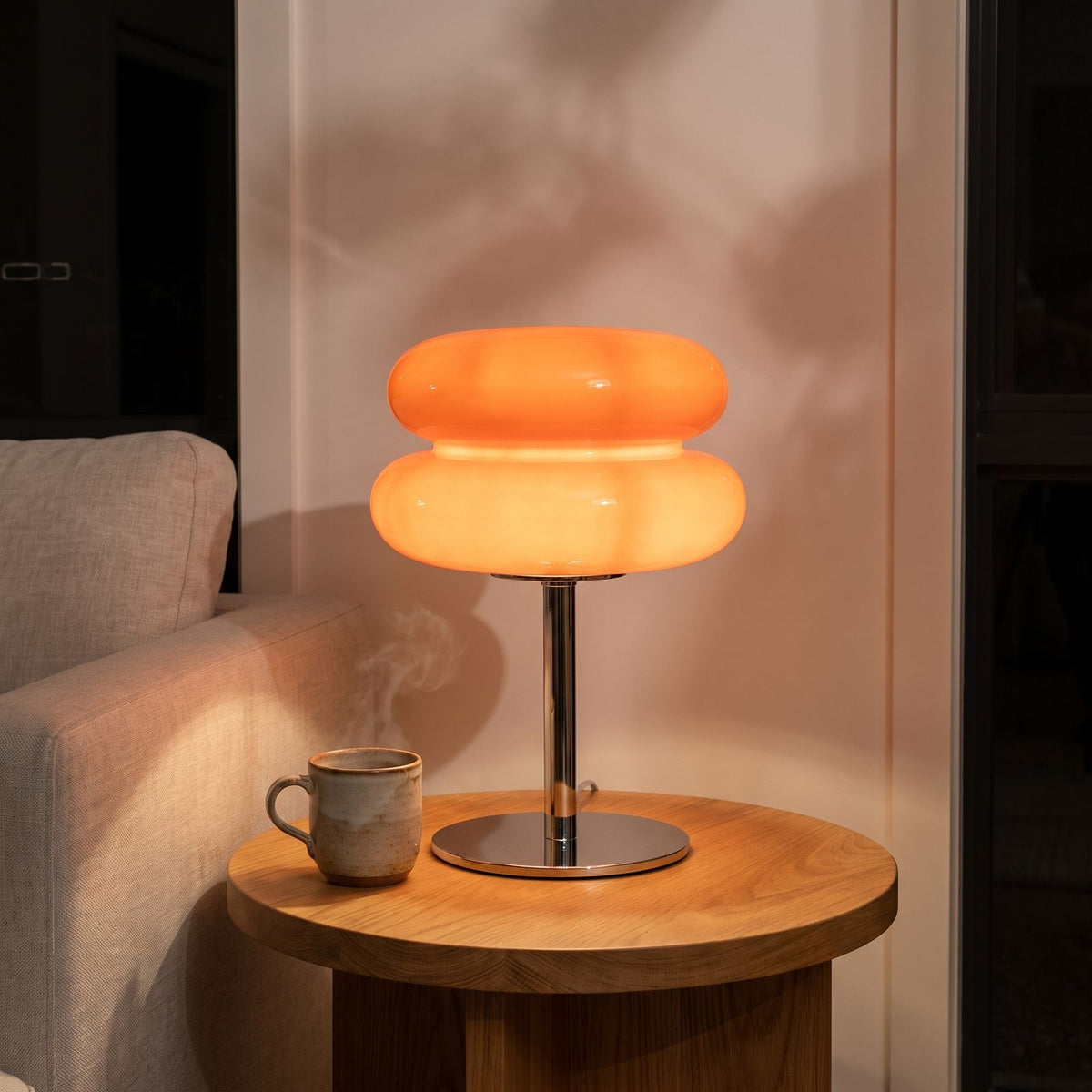 Orange stacked bubble table lamp on a side table beside a sofa
