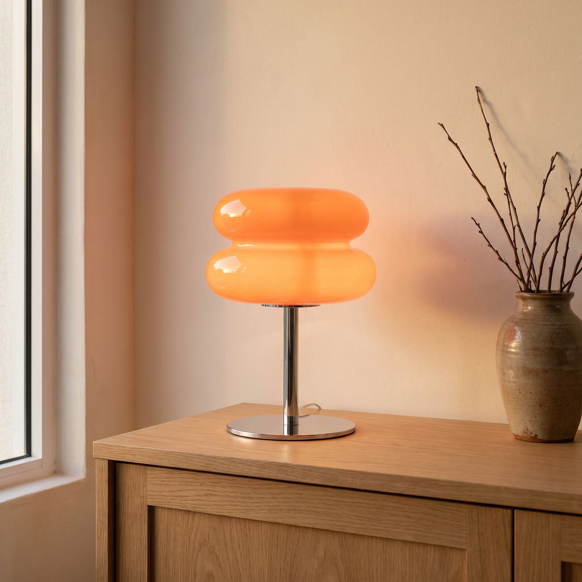 Orange stacked bubble table lamp on an oak entryway sideboard