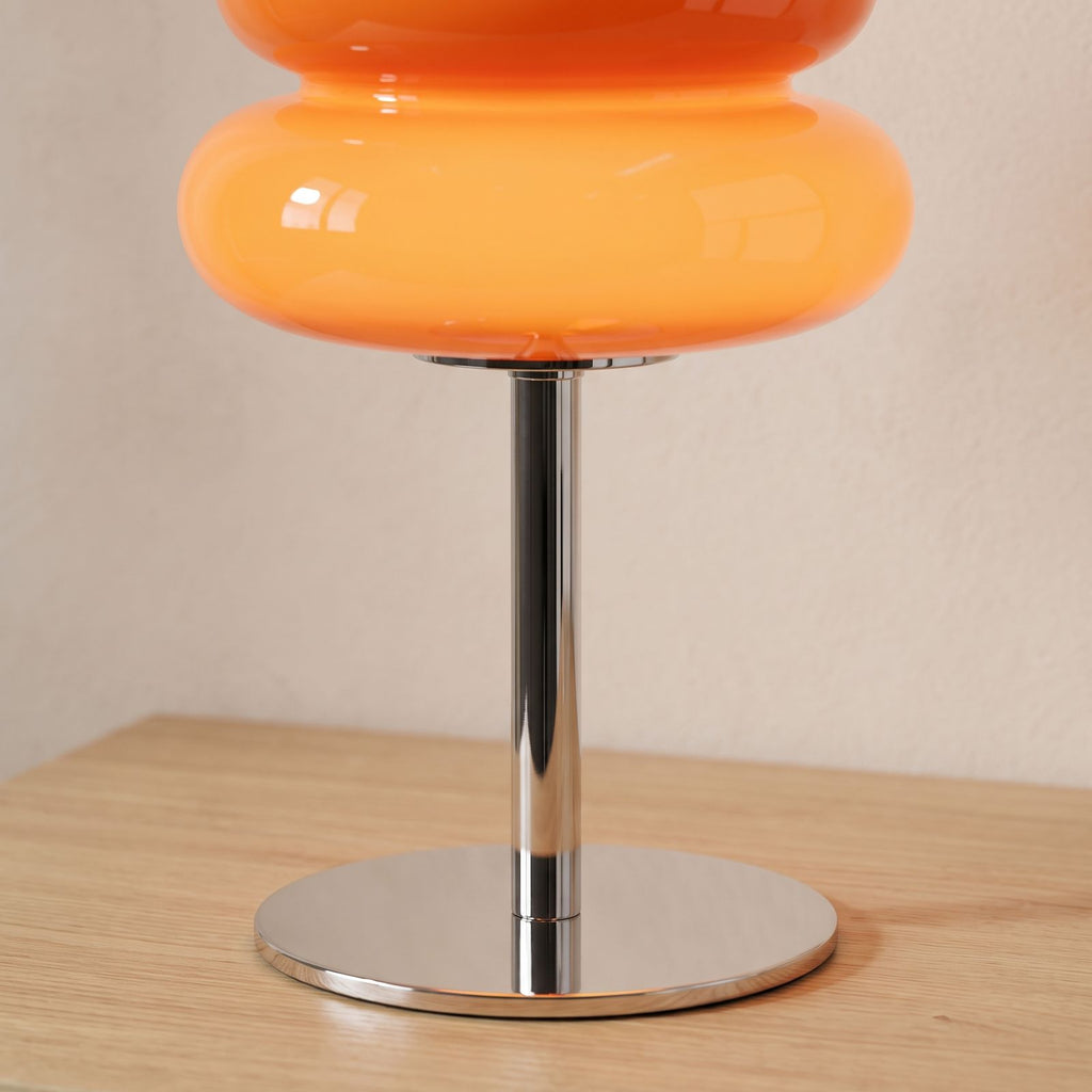 Close-up of the chrome stem and base under the orange acrylic shade