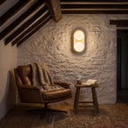 Stacked Frosted Globe Travertine Wall Light in Natural Wood above a leather armchair in a farmhouse reading nook
