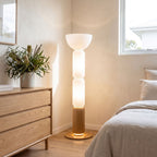 Stacked glass capsule floor lamp in a bedroom corner in daylight