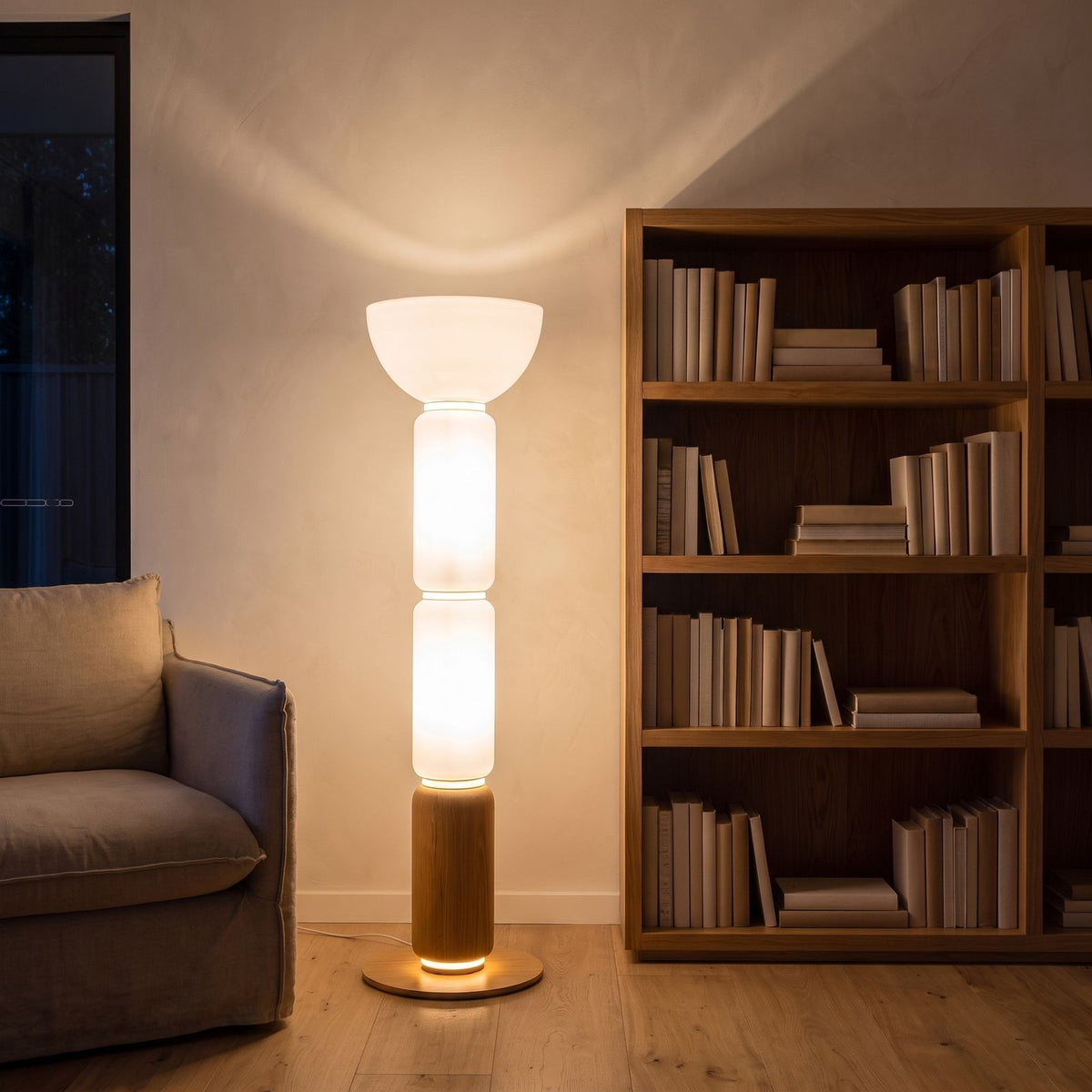 Stacked glass capsule floor lamp in a reading corner at night