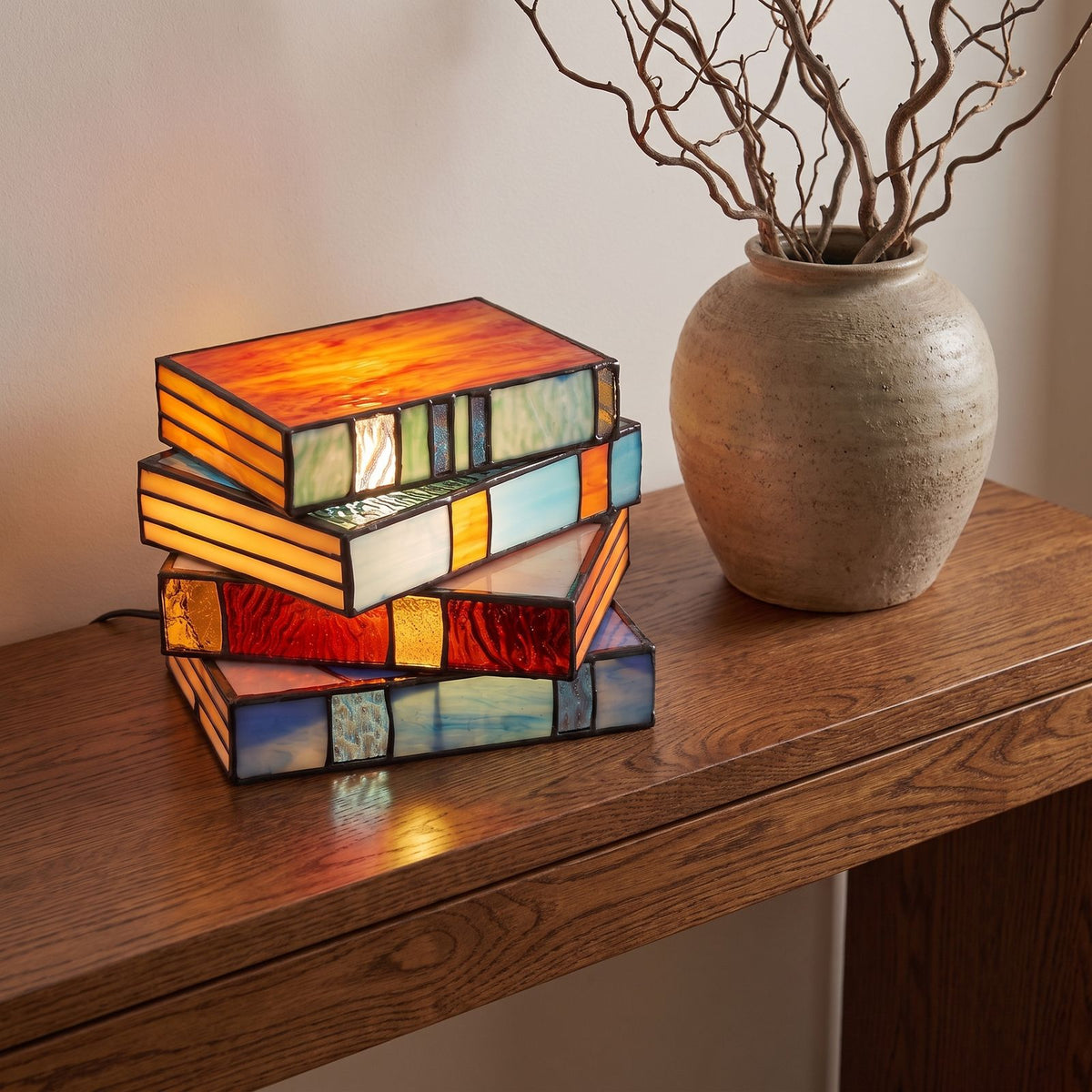 Stained glass stacked books table lamp on an entry console