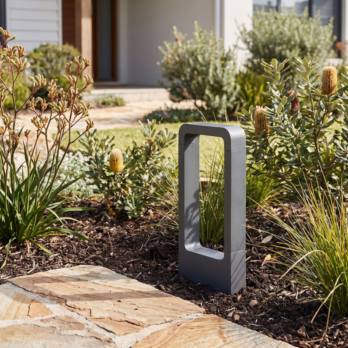 Stainless Steel Solar Floor Light in a garden bed beside a path