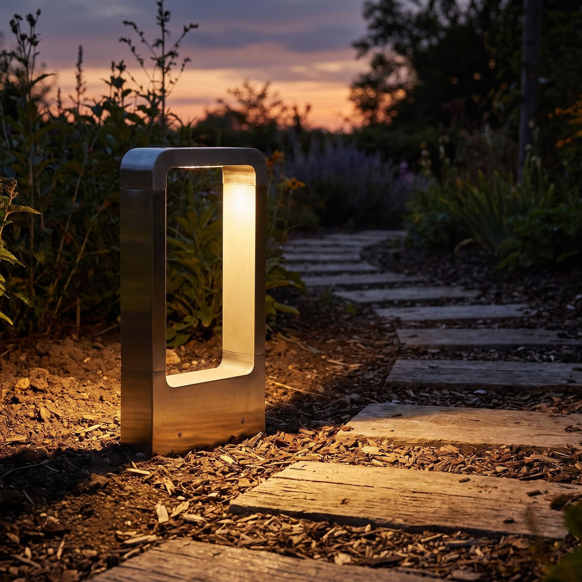 Stainless Steel Solar Floor Light beside a garden path at dusk