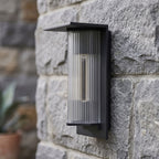 Striped Acrylic Cylinder Outdoor Wall Light, close view at 45 degrees on a stone wall