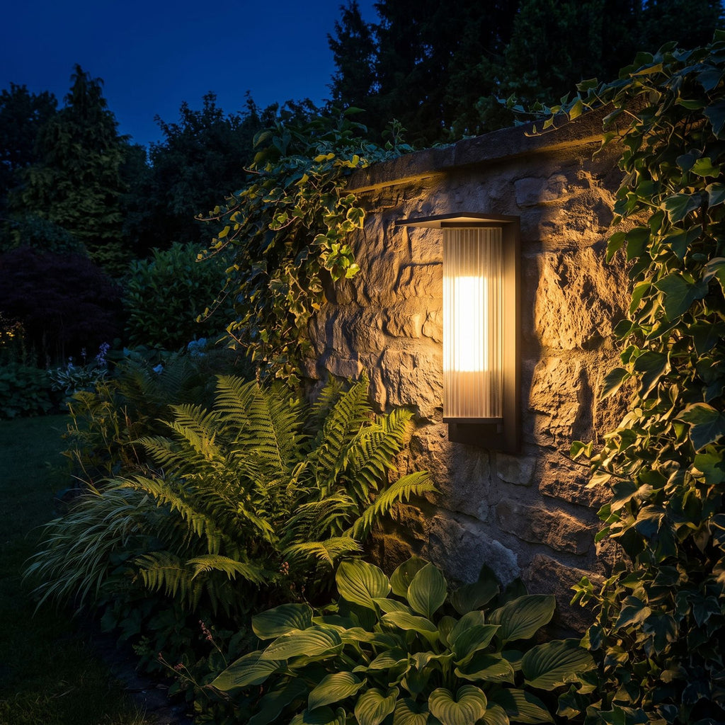 Striped Acrylic Cylinder Outdoor Wall Light glowing on a garden wall at night
