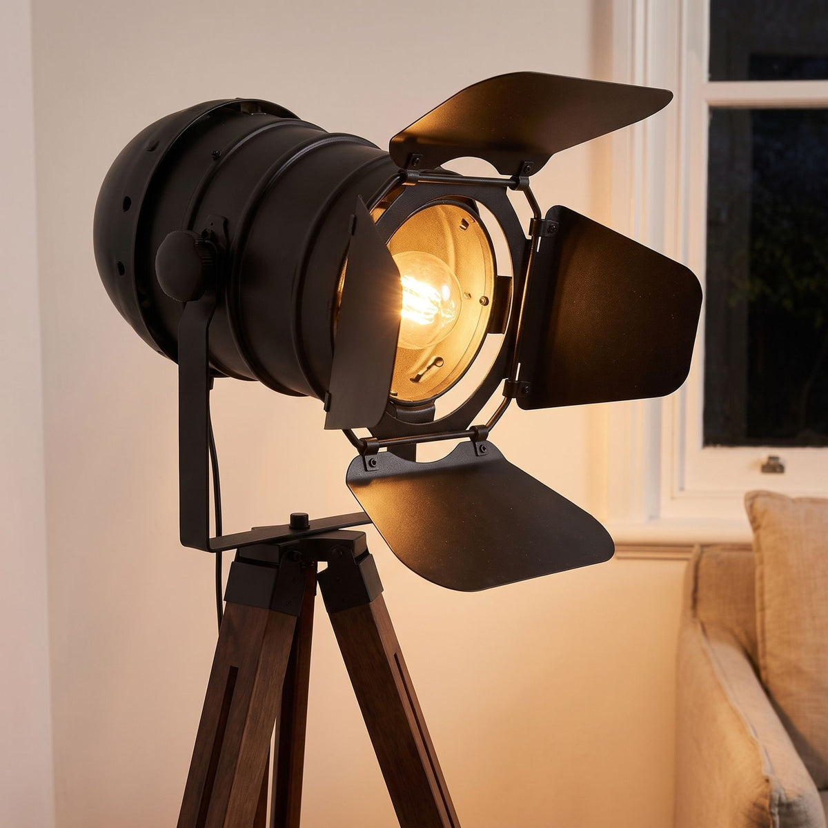Close-up of the black spotlight head, barn doors and wooden tripod top