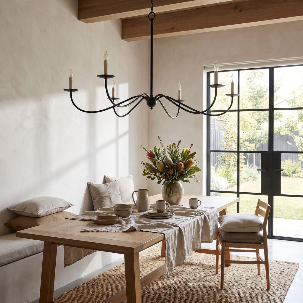 Sweeping Curved Arm Six Light Chandelier in a styled bedroom in soft daylight