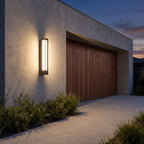 Tall Black Frame LED Outdoor Wall Light beside a timber garage door at dusk