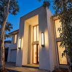 Two Tall Black Frame LED Outdoor Wall Lights on a double height facade at blue hour