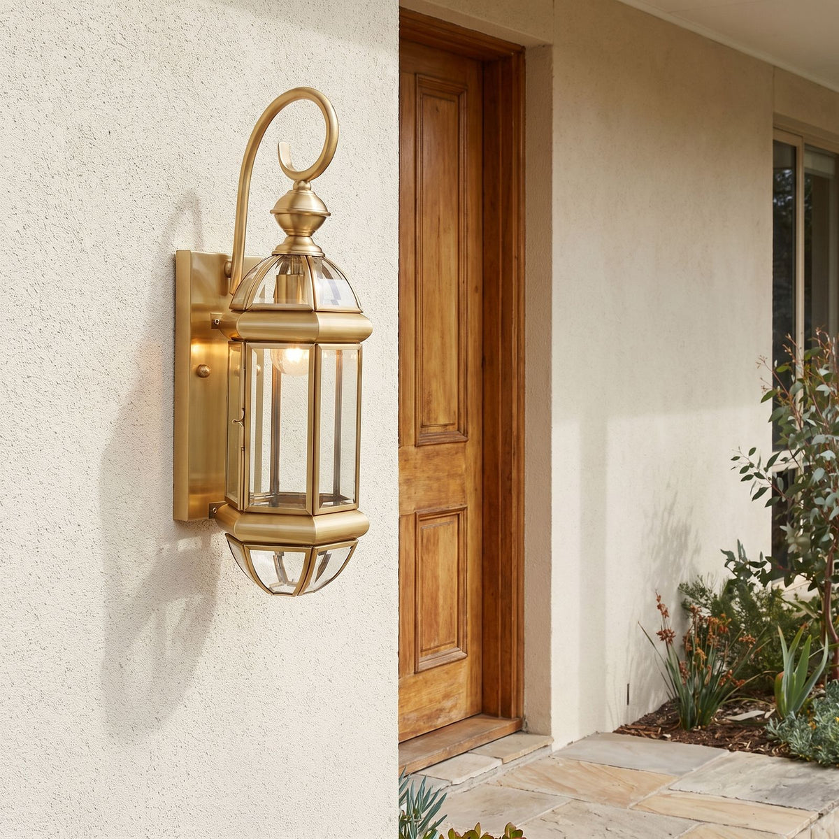 Tall Brass and Clear Glass Outdoor Wall Lantern beside a timber front door