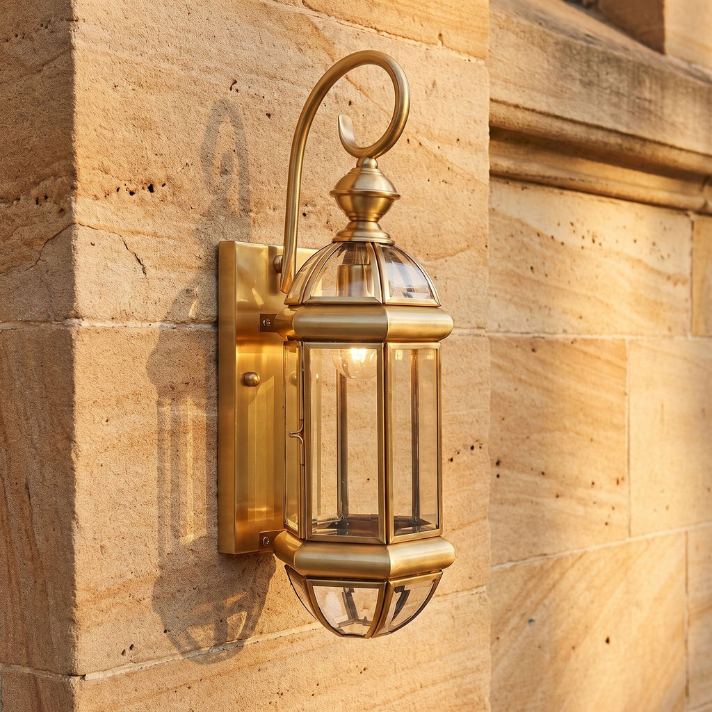 Tall Brass and Clear Glass Outdoor Wall Lantern, close view at 45 degrees on a stone wall