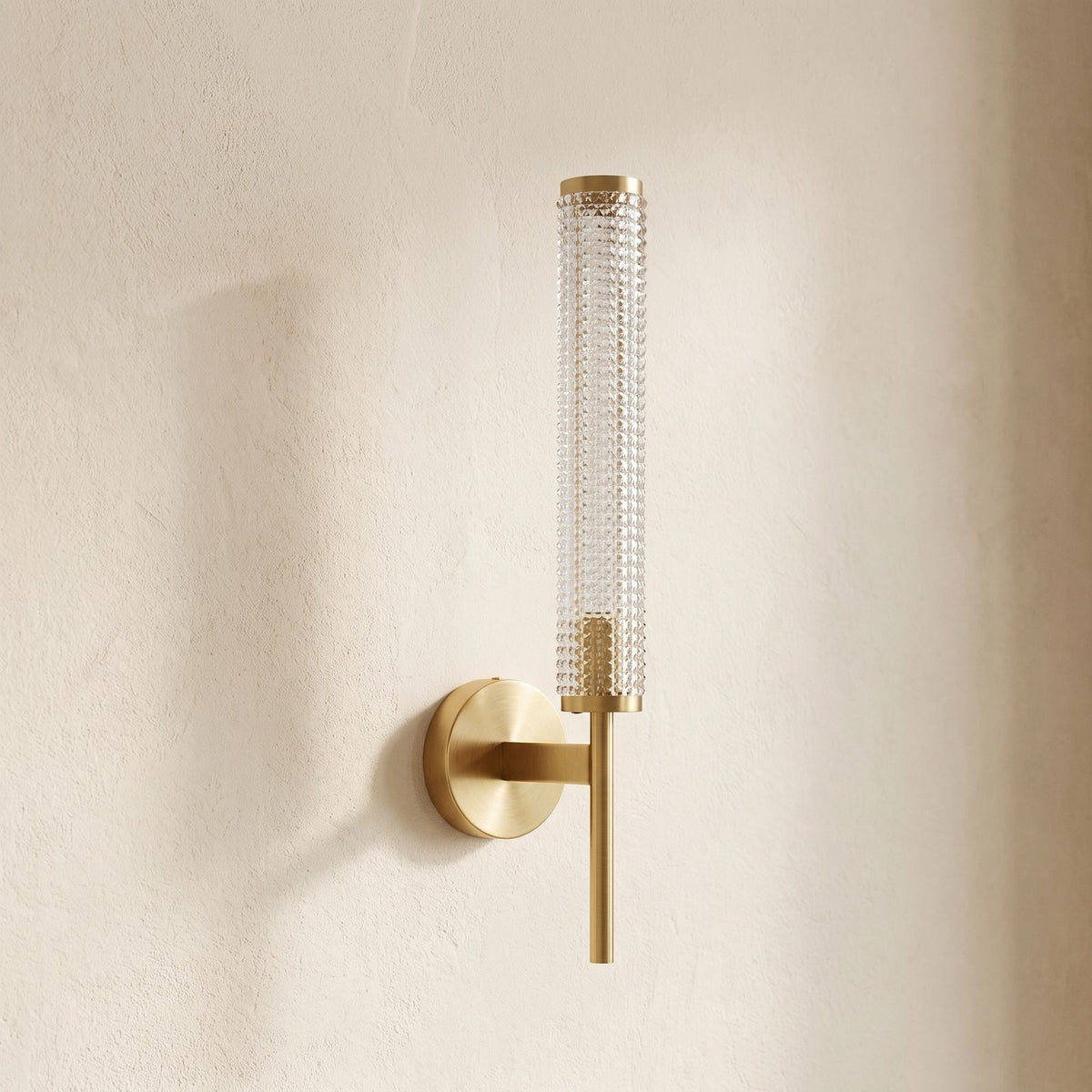 Tall Brass and Textured Glass Wall Sconce, close view at 45 degrees on a plaster wall